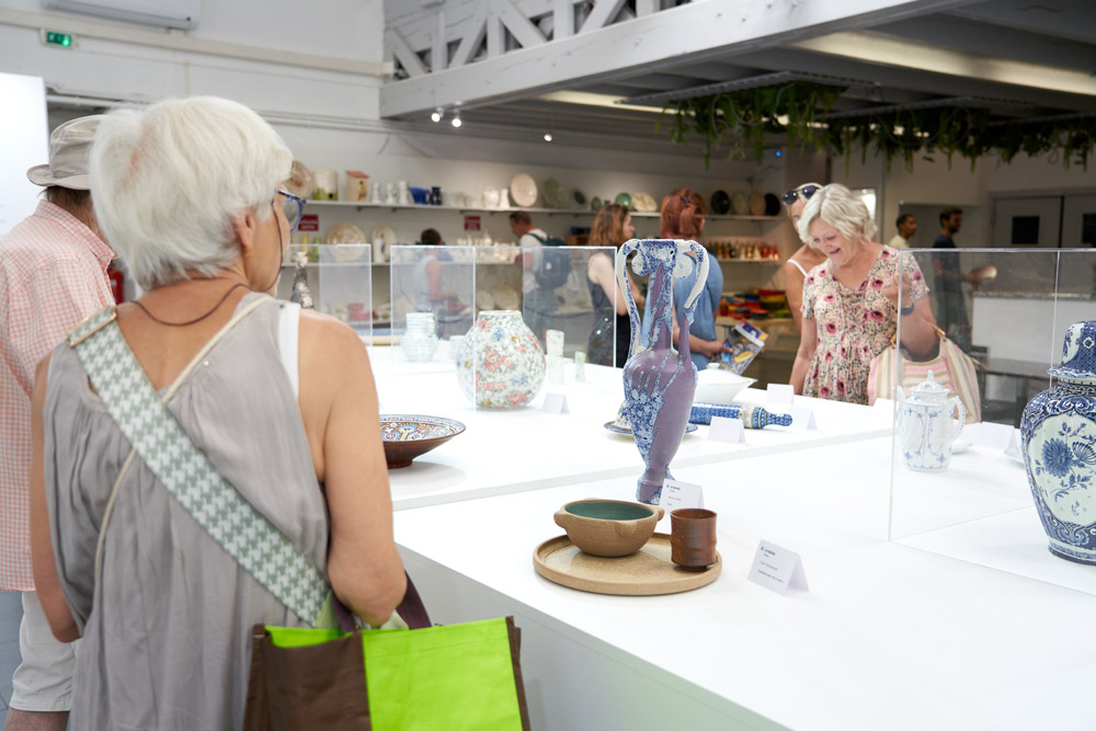 Le public admire les créations des artisans qui ont façonné le patrimoine céramique européen.